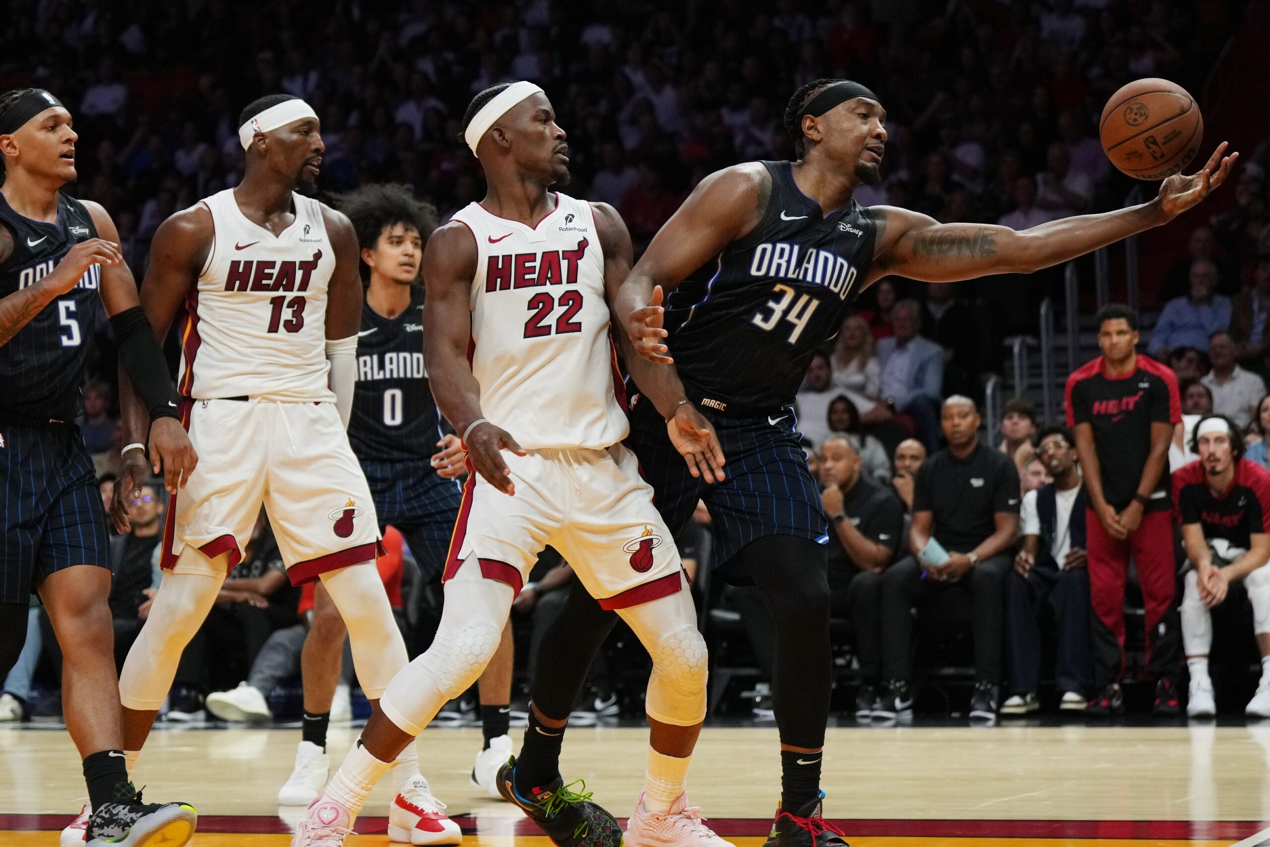 Oct 23, 2024; Miami, Florida, USA; Orlando Magic center Wendell Carter Jr. (34) reaches for a rebound as Miami Heat forward Jimmy Butler (22) looks on during the first half at Kaseya Center. Mandatory Credit: Jim Rassol-Imagn Images