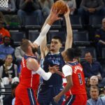 NBA: Memphis Grizzlies rookie Zach Edey (14) handles the ball as Washington Wizards center Jonas Valanciunas (17) and rookie Bub Carrington (8) defend