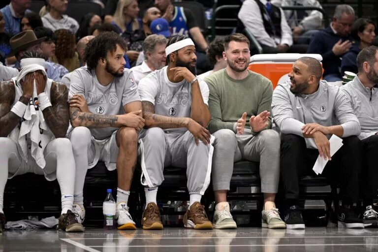Dallas Mavericks center Dereck Lively II and forward Markieff Morris and guard Luka Doncic sit on the team bench during the second quarter of the game between the Mavericks and the New York Knicks