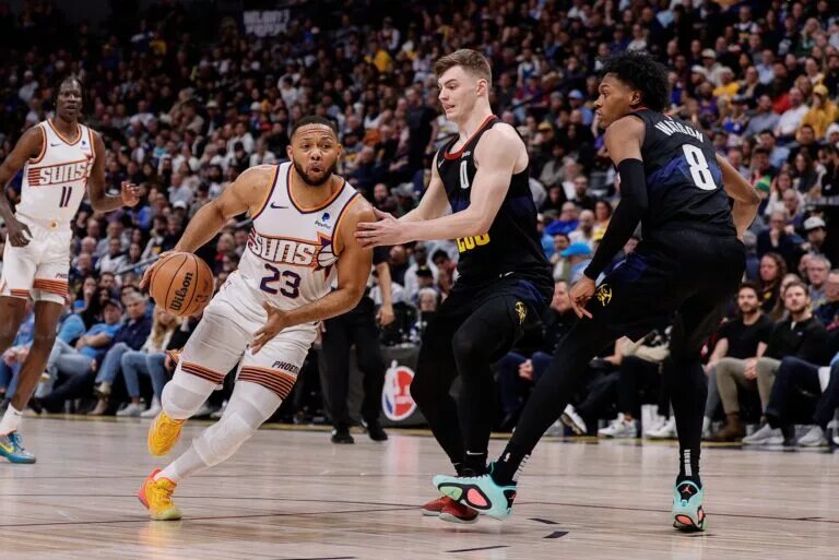 Phoenix Suns guard Eric Gordon (23) controls the ball against Denver Nuggets guard Christian Braun (0) and forward Peyton Watson (8)