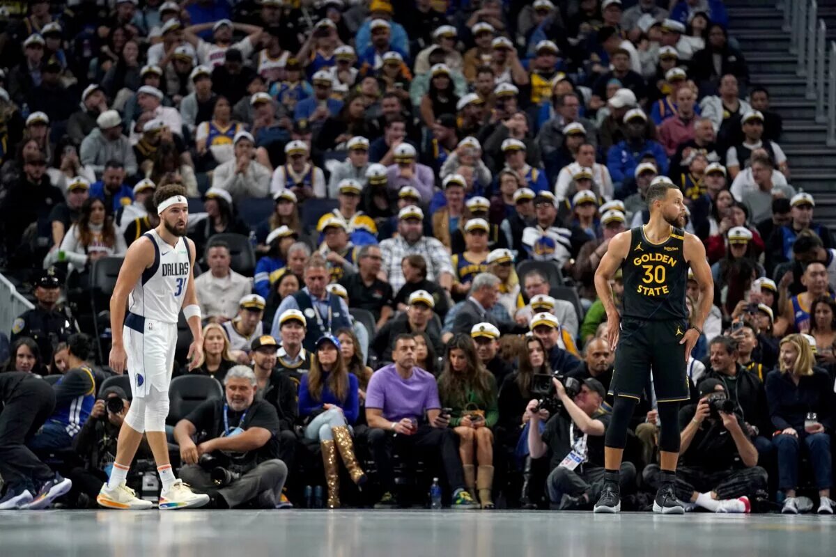 Golden State Warriors guard Stephen Curry (30) and Dallas Mavericks guard Klay Thompson (31) stand on the court