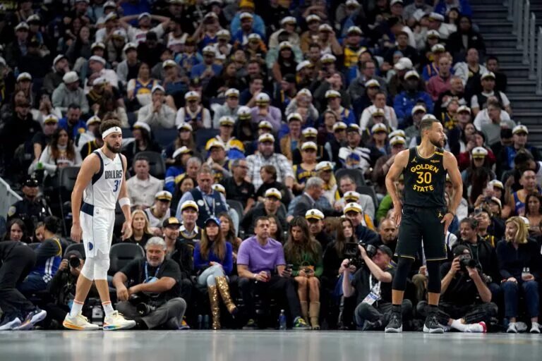 Golden State Warriors guard Stephen Curry (30) and Dallas Mavericks guard Klay Thompson (31) stand on the court