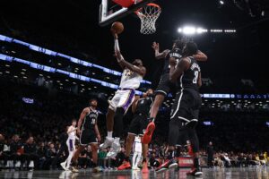 Mar 31, 2024; Brooklyn, New York, USA; Los Angeles Lakers forward LeBron James (23) drives for a shot against Brooklyn Nets forward Noah Clowney (21) an dforward Dorian Finney-Smith (28) during the second half at Barclays Center. Mandatory Credit: Vincent Carchietta-USA TODAY Sports