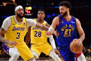 Apr 25, 2024; Los Angeles, California, USA; Denver Nuggets guard Jamal Murray (27) moves the ball Los Angeles Lakers forward Anthony Davis (3) and forward Rui Hachimura (28) during the first half in game three of the first round for the 2024 NBA playoffs at Crypto.com Arena. Mandatory Credit: Gary A. Vasquez-USA TODAY Sports