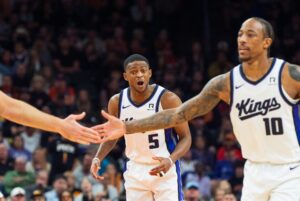 Nov 10, 2024; Phoenix, Arizona, USA; Sacramento Kings guard De'Aaron Fox (5) reacts after guard-forward DeMar DeRozan (10) scores in the second half during a game against the Phoenix Suns at Footprint Center. Mandatory Credit: Allan Henry-Imagn Images