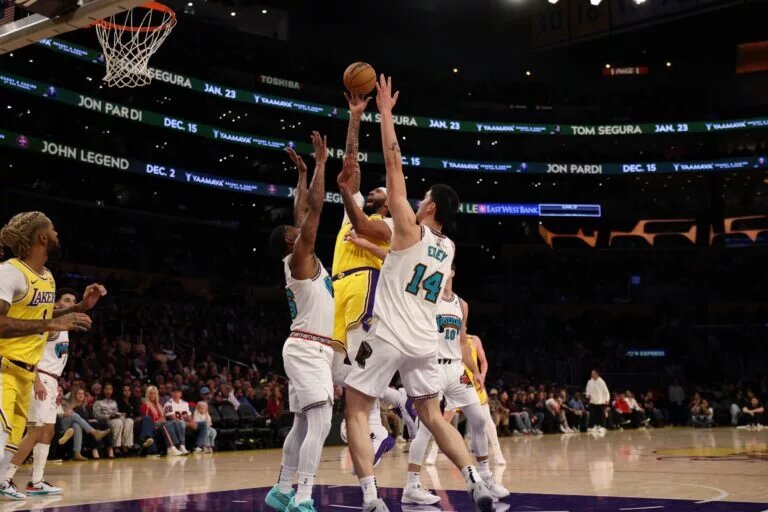 Nov 13, 2024; Los Angeles, California, USA; Los Angeles Lakers forward Anthony Davis (3) shoots the ball between Memphis Grizzlies guard Marcus Smart (36) and center Zach Edey (14) during the first quarter at Crypto.com Arena. Mandatory Credit: Kiyoshi Mio-Imagn Images