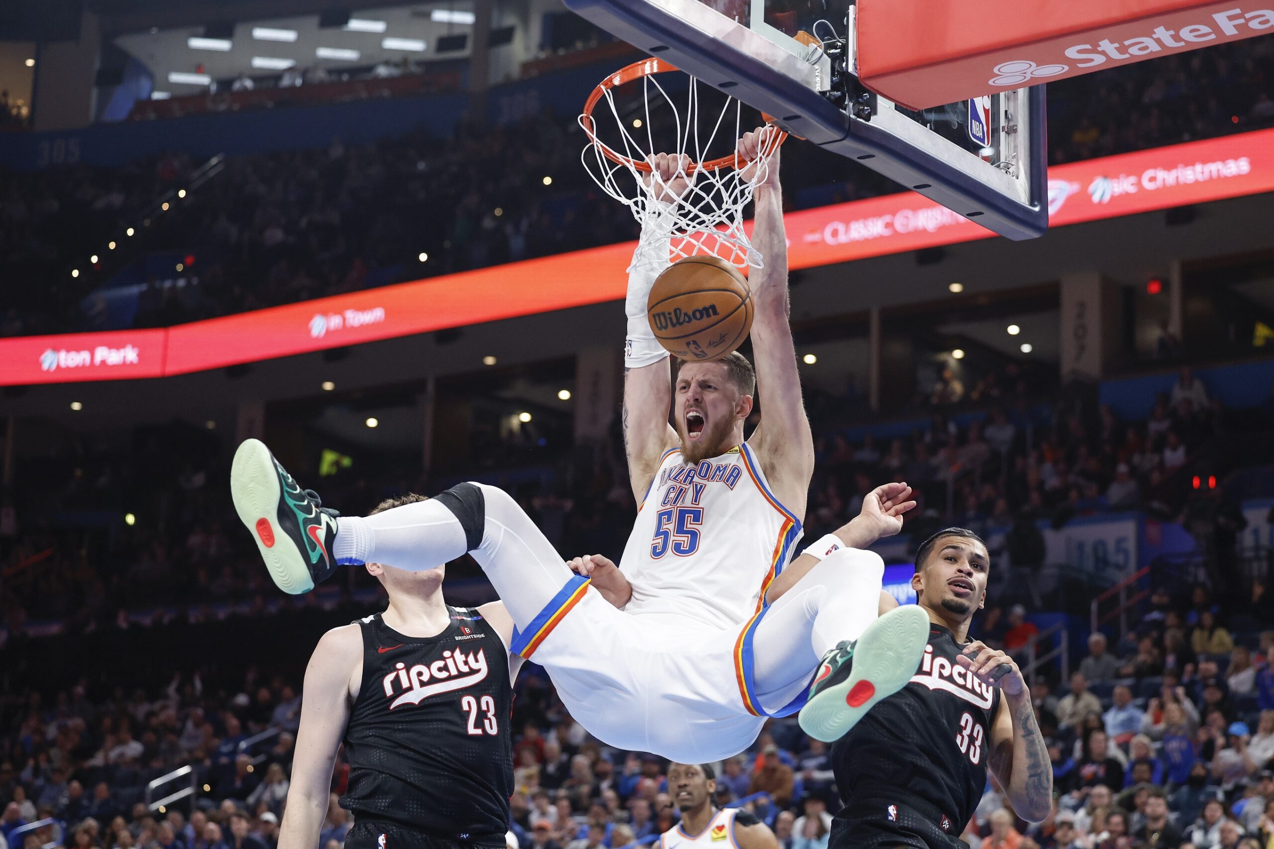 Nov 20, 2024; Oklahoma City, Oklahoma, USA; Oklahoma City Thunder center Isaiah Hartenstein (55) celebrates a dunk between Portland Trail Blazers center Donovan Clingan (23) and forward Toumani Camara (33) during the second half at Paycom Center. Mandatory Credit: Alonzo Adams-Imagn Images