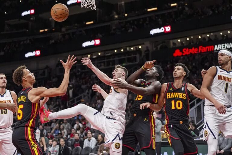 Denver Nuggets guard Christian Braun (0) fights for a rebound with Atlanta Hawks guard Dyson Daniels (5)
