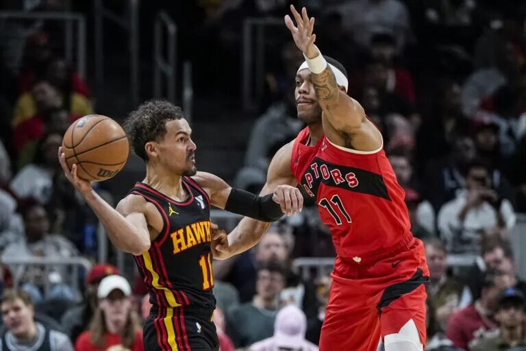Atlanta Hawks guard Trae Young (11) tries to pass against Toronto Raptors wing Bruce Brown (11)