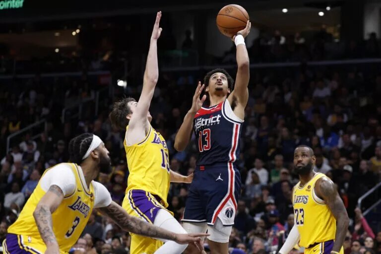 Washington Wizards guard Jordan Poole (13) shoots the ball as Los Angeles Lakers guard Austin Reaves (15) defends