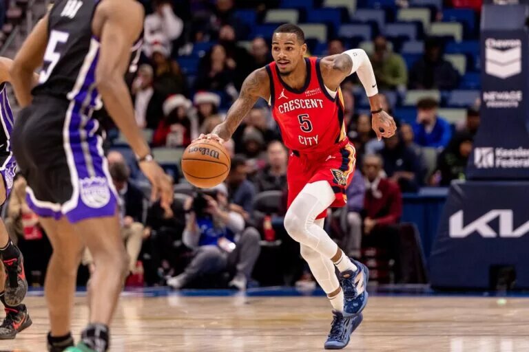 New Orleans Pelicans guard Dejounte Murray (5) brings the ball up court against Sacramento Kings guard De'Aaron Fox (5
