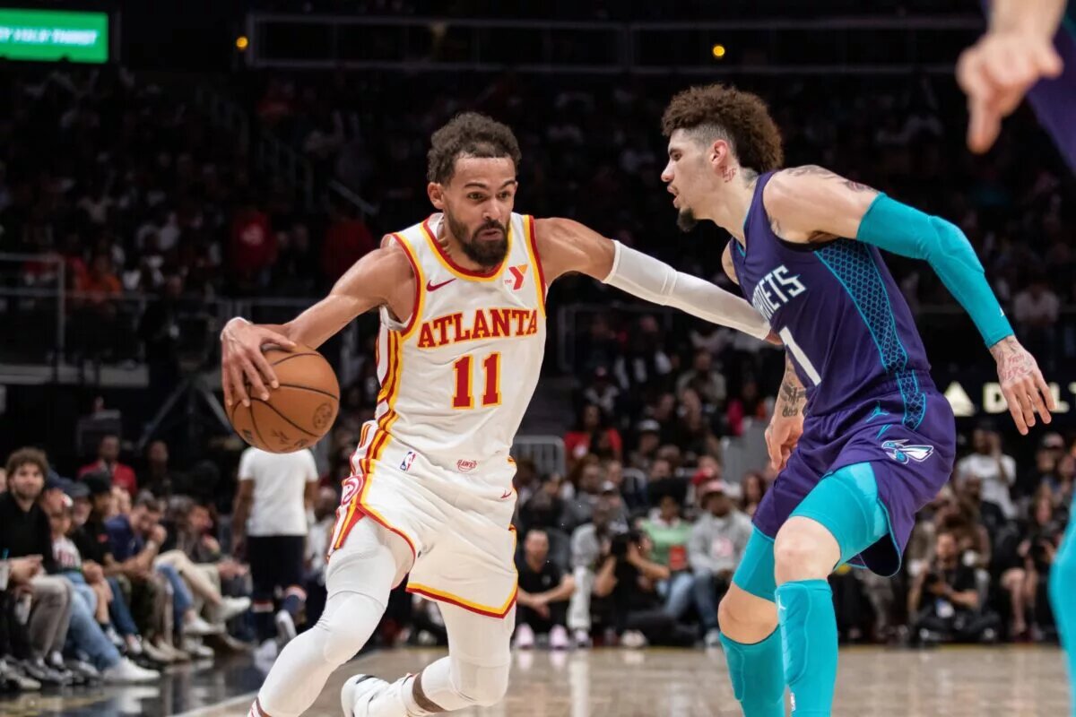 Atlanta Hawks guard Trae Young (11) protects the ball against Charlotte Hornets guard LaMelo Ball (1)