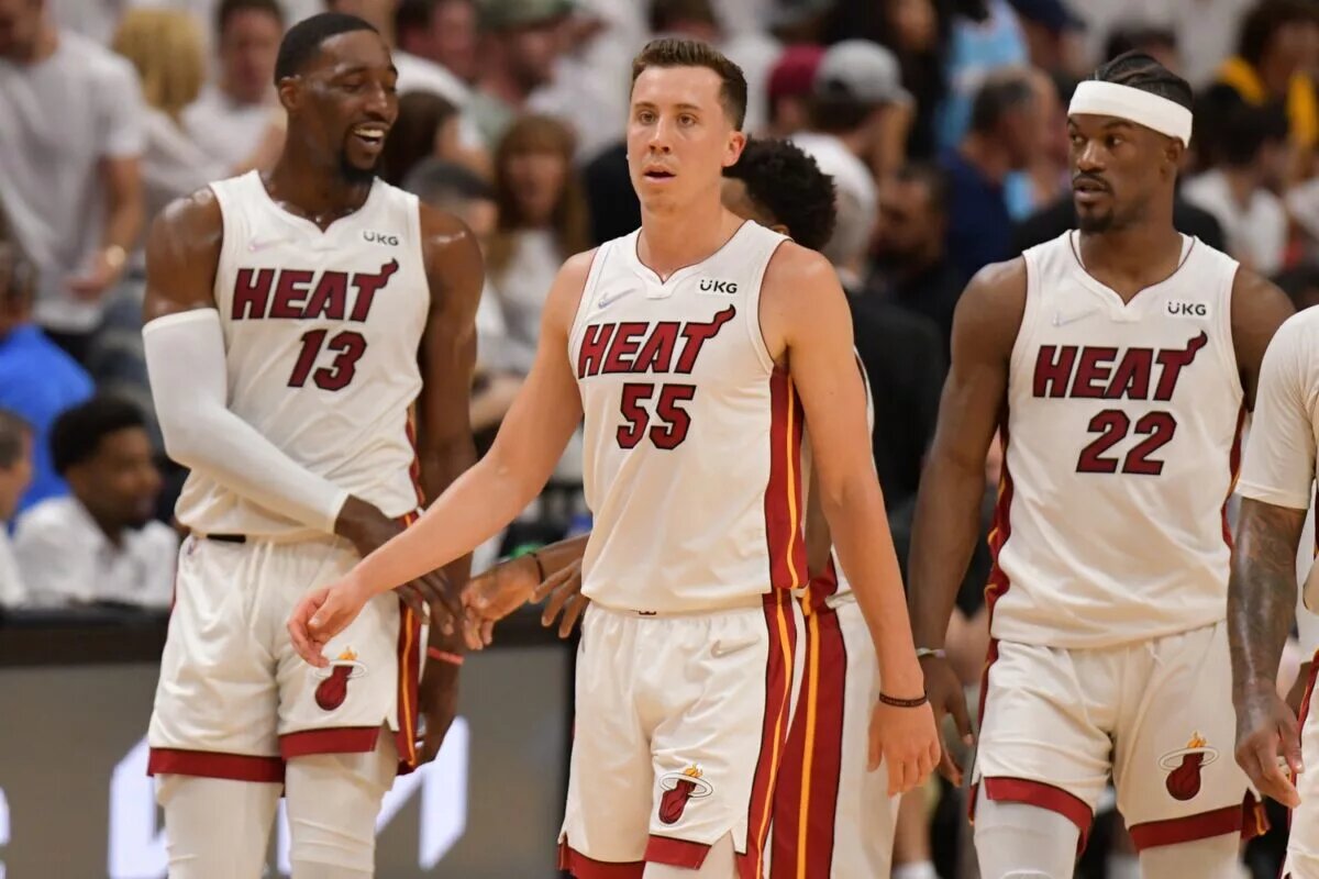 Apr 17, 2022; Miami, Florida, USA; Miami Heat guard Duncan Robinson (55) and teammates center Bam Adebayo (13) and forward Jimmy Butler (22) return to the court following a timeout in the game against the Atlanta hawks during the first half of game one of the first round for the 2022 NBA playoffs at FTX Arena. Mandatory Credit: Jim Rassol-USA TODAY Sports