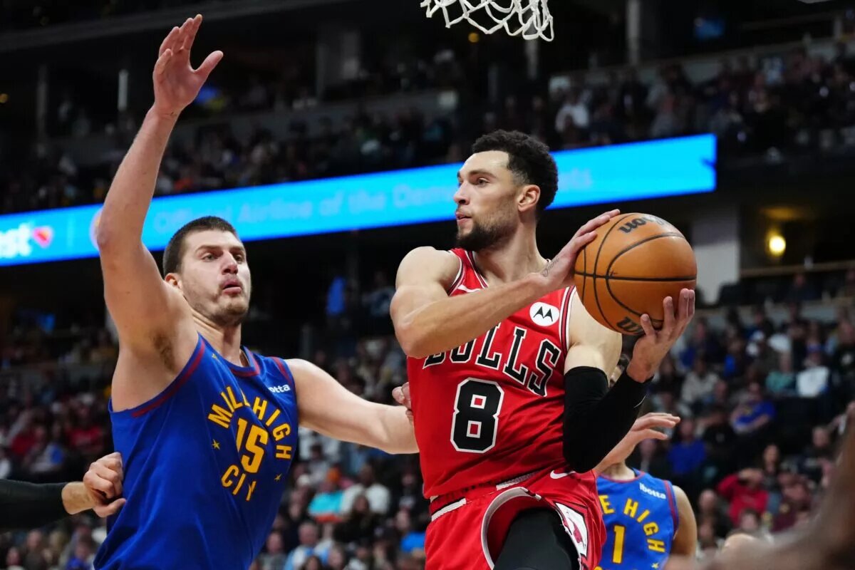 Chicago Bulls guard Zach LaVine makes a pass while guarded by Denver Nuggets center Nikola Jokic
