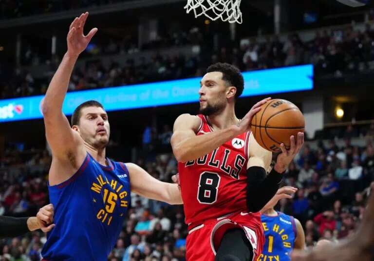 Chicago Bulls guard Zach LaVine makes a pass while guarded by Denver Nuggets center Nikola Jokic
