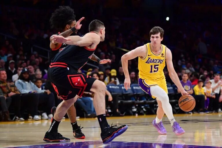 Jan 25, 2024; Los Angeles, California, USA; Los Angeles Lakers guard Austin Reaves (15) moves the ball against Chicago Bulls center Nikola Vucevic (9) during the first half at Crypto.com Arena. Mandatory Credit: Gary A. Vasquez-USA TODAY Sports