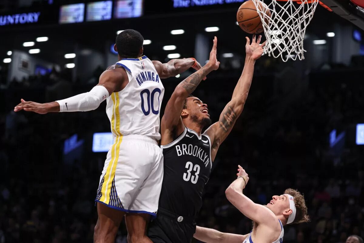 Feb 5, 2024; Brooklyn, New York, USA; Brooklyn Nets center Nic Claxton (33) drives for a shot as Golden State Warriors forward Jonathan Kuminga (00) and guard Brandin Podziemski (2) defend during the first quarter against the Brooklyn Nets at Barclays Center. Mandatory Credit: Vincent Carchietta-USA TODAY Sports