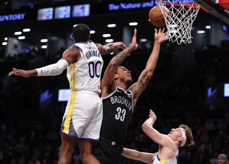Feb 5, 2024; Brooklyn, New York, USA; Brooklyn Nets center Nic Claxton (33) drives for a shot as Golden State Warriors forward Jonathan Kuminga (00) and guard Brandin Podziemski (2) defend during the first quarter against the Brooklyn Nets at Barclays Center. Mandatory Credit: Vincent Carchietta-USA TODAY Sports