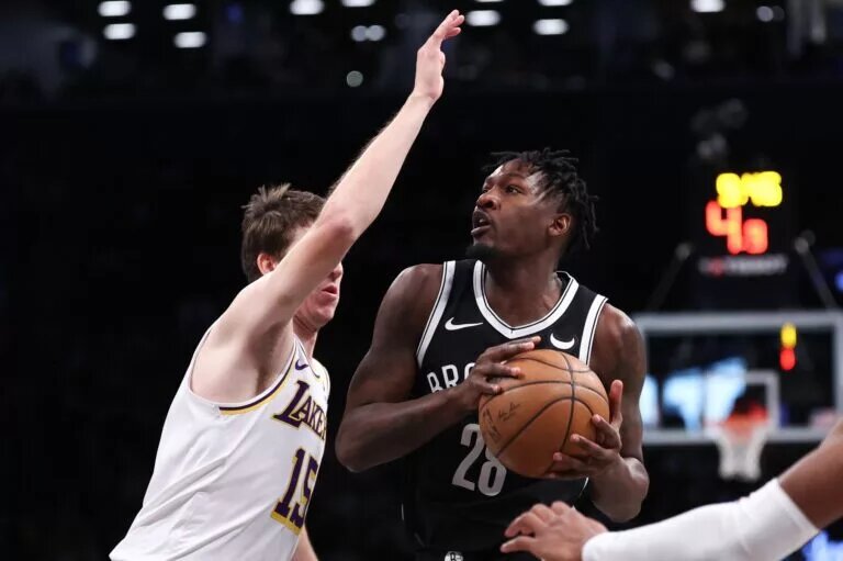 Mar 31, 2024; Brooklyn, New York, USA; Brooklyn Nets forward Dorian Finney-Smith (28) looks to the basket against Los Angeles Lakers guard Austin Reaves (15) during the first quarter at Barclays Center. Mandatory Credit: Vincent Carchietta-USA TODAY Sports