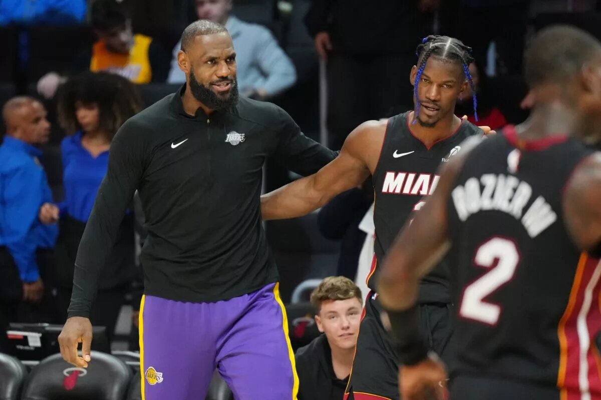 Los Angeles Lakers forward LeBron James and Miami Heat forward Jimmy Butler embrace on the sideline
