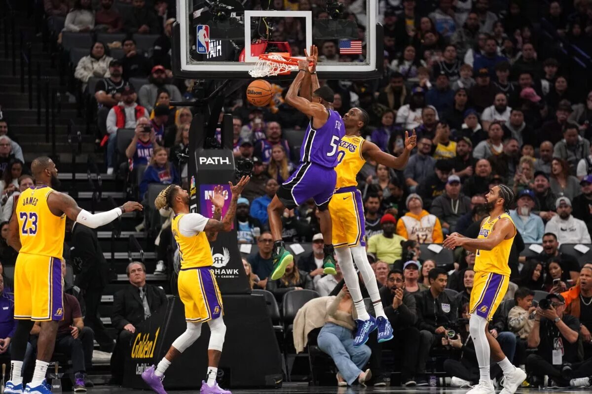 Dec 19, 2024; Sacramento, California, USA; Sacramento Kings guard De'Aaron Fox (5) dunks the ball next to Los Angeles Lakers center Christian Koloko (10) in the second quarter at the Golden 1 Center. Mandatory Credit: Cary Edmondson-Imagn Images