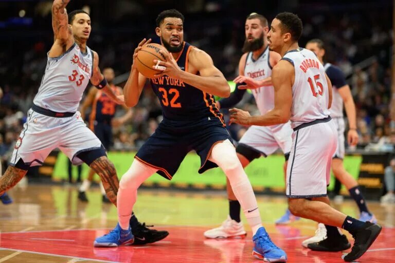 New York Knicks center Karl-Anthony Towns surrounded by Washington Wizards center Jonas Valanciunas, guard Malcolm Brogdon, and forward Kyle Kuzma