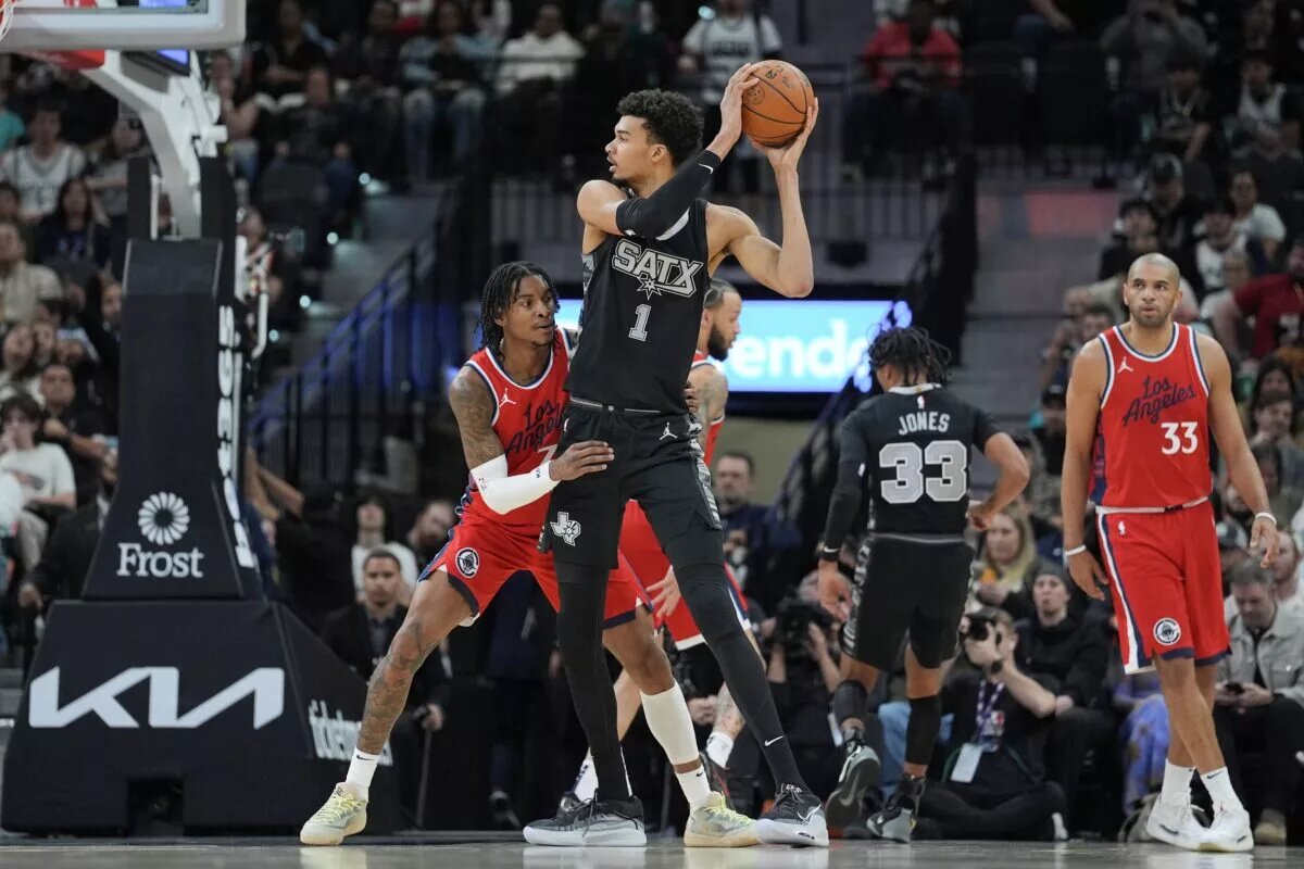 Dec 31, 2024; San Antonio, Texas, USA; San Antonio Spurs center Victor Wembanyama (1) looks to pass against LA Clippers guard Kevin Porter Jr. (77) in the first half at Frost Bank Center.