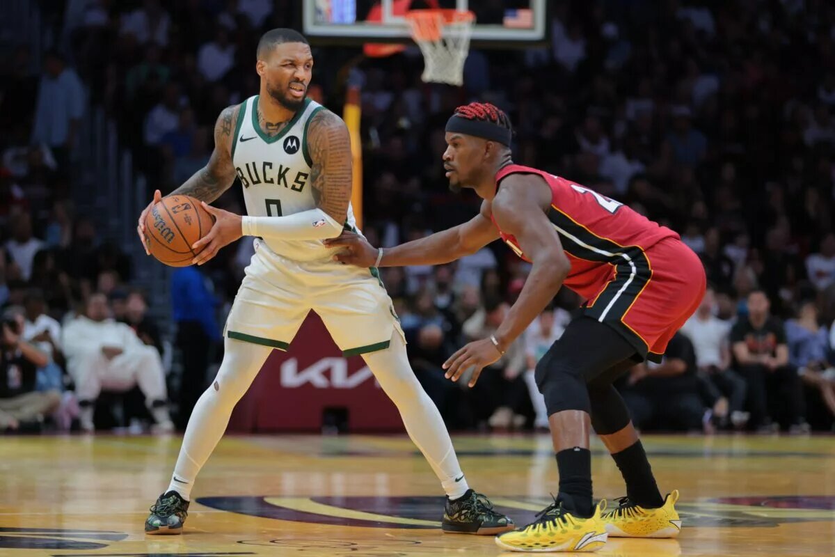 Milwaukee Bucks guard Damian Lillard (0) protects the basketball from Miami Heat forward Jimmy Butler (22)