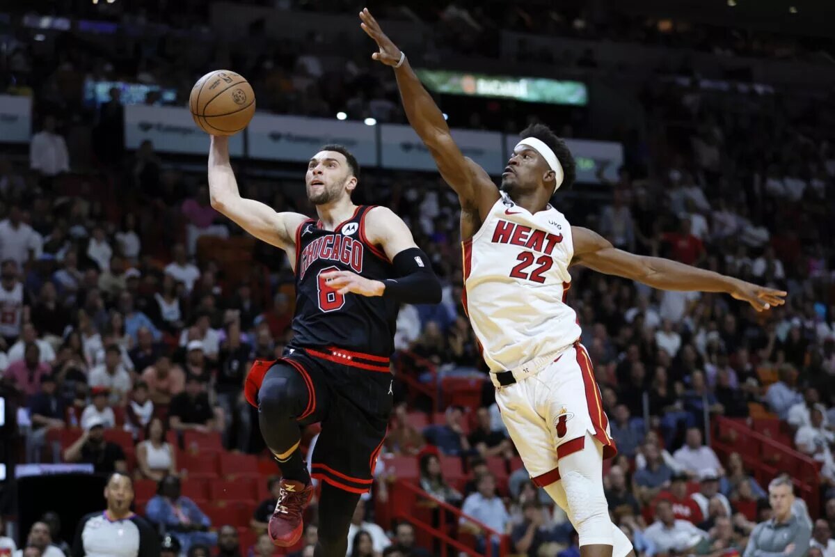 Chicago Bulls guard Zach LaVine dunks while guarded by Miami Heat forward Jimmy Butler