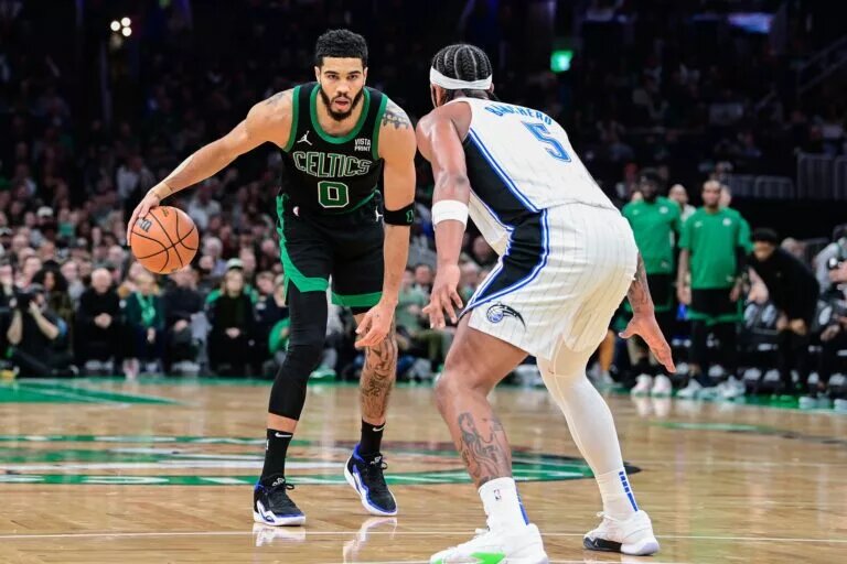 Boston Celtics forward Jayson Tatum sizes up Orlando Magic forward Paolo Banchero