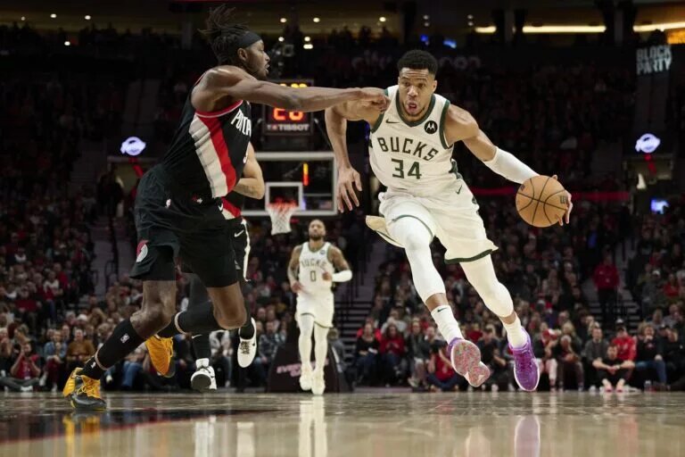 Milwaukee Bucks forward Giannis Antetokounmpo is guarded by Portland Trail Blazers forward Jerami Grant