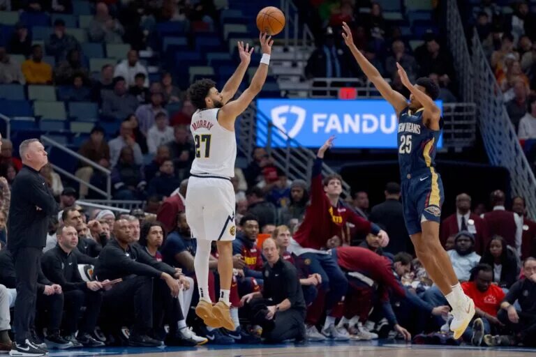 Dec 22, 2024; New Orleans, Louisiana, USA; Denver Nuggets guard Jamal Murray (27) shoots a three point basket against New Orleans Pelicans guard Trey Murphy III (25) during the first half at Smoothie King Center. Mandatory Credit: Matthew Hinton-Imagn Images