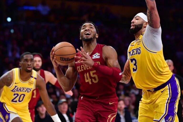 Dec 31, 2024; Los Angeles, California, USA; Cleveland Cavaliers guard Donovan Mitchell (45) moves to the basket against Los Angeles Lakers forward Anthony Davis (3) during the second half at Crypto.com Arena. Mandatory Credit: Gary A. Vasquez-Imagn Images