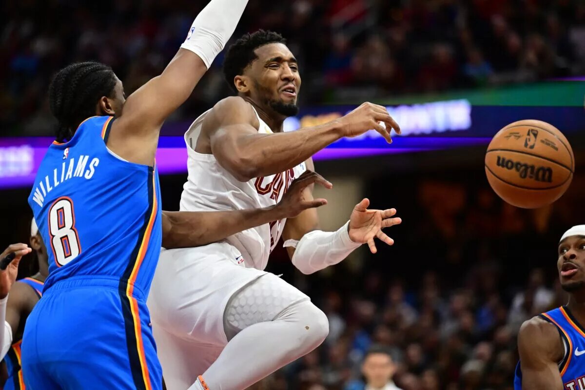 Jan 8, 2025; Cleveland, Ohio, USA; Cleveland Cavaliers guard Donovan Mitchell (45) loses the ball as he drives to the basket against Oklahoma City Thunder forward Jalen Williams (8) during the second half at Rocket Mortgage FieldHouse.