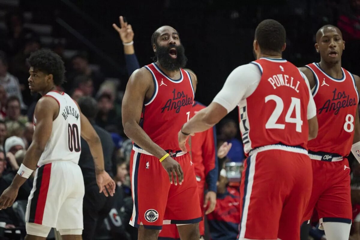 LA Clippers guard James Harden (1) celebrates with guard Norman Powell (24) after scoring a three point basket during the second half against the Portland Trail Blazers at Moda Center.