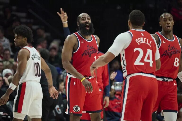 LA Clippers guard James Harden (1) celebrates with guard Norman Powell (24) after scoring a three point basket during the second half against the Portland Trail Blazers at Moda Center.