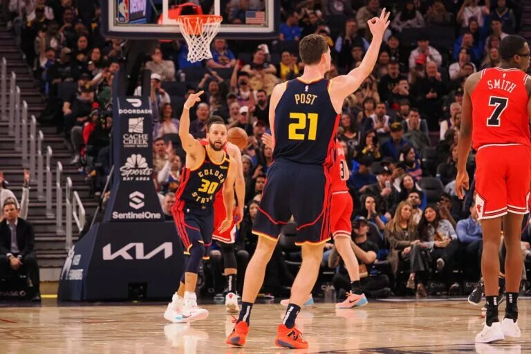 Golden State Warriors guard Stephen Curry and center Quinten Post celebrate a three-point basket