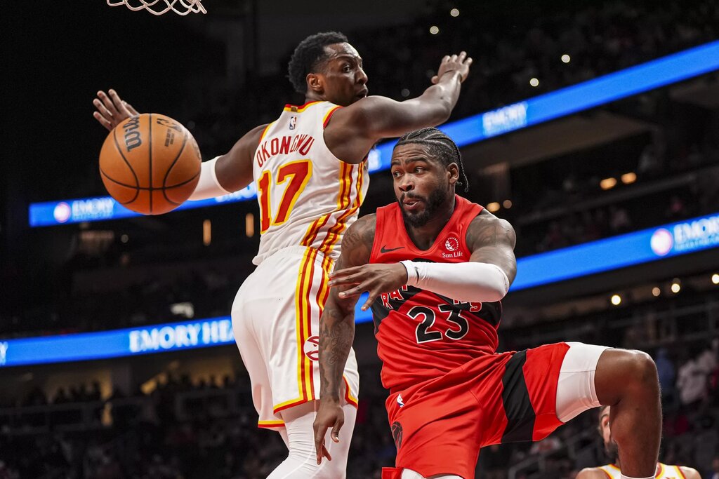 Jan 25, 2025; Atlanta, Georgia, USA; Toronto Raptors guard Jamal Shead (23) passes past Atlanta Hawks forward Onyeka Okongwu (17) during the second half at State Farm Arena. Mandatory Credit: Dale Zanine-Imagn Images