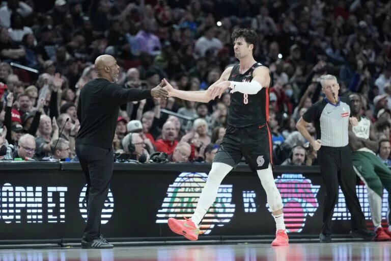 Portland Trail Blazers head coach Chauncey Billups and small forward Deni Avdija (8) high five during the second half against the Milwaukee Bucks at Moda Center.