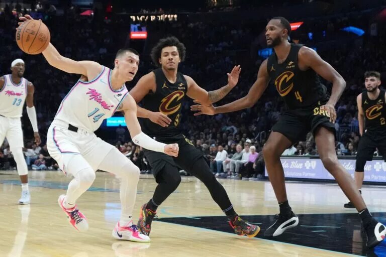 Jan 29, 2025; Miami, Florida, USA; Miami Heat guard Tyler Herro (14) drives toward the basket as Cleveland Cavaliers guard Craig Porter Jr. (9) and forward Evan Mobley (4) defend during the second half at Kaseya Center.