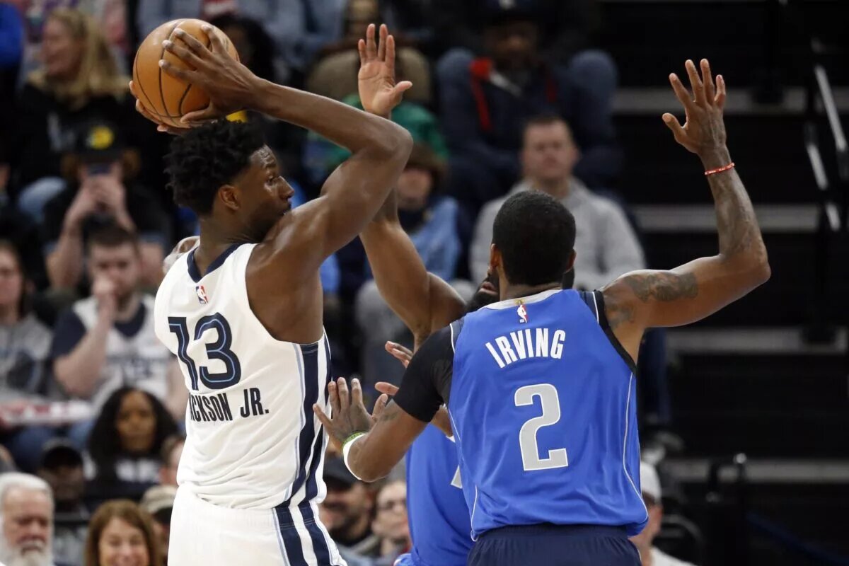 Mar 20, 2023; Memphis, Tennessee, USA; Memphis Grizzlies forward Jaren Jackson Jr. (13) passes the ball as Dallas Mavericks guard Kyrie Irving (2) defends during the first half at FedExForum.
