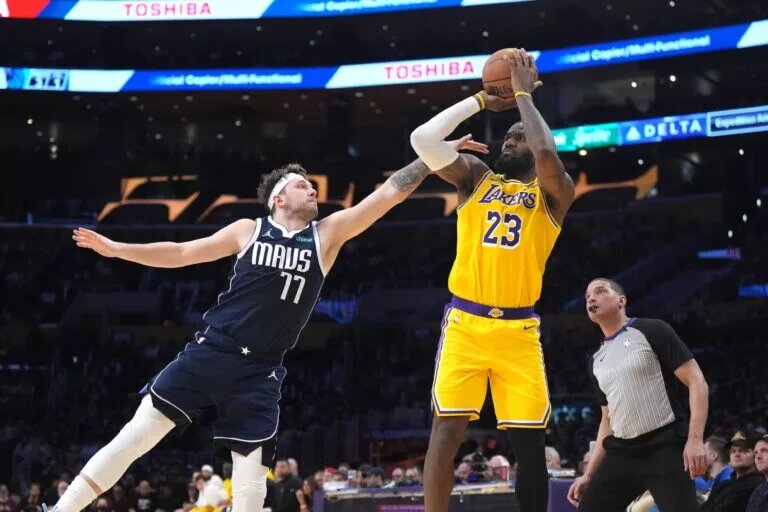 Jan 17, 2024; Los Angeles, California, USA; Los Angeles Lakers forward LeBron James (23) shoots the ball against Dallas Mavericks guard Luka Doncic (77) in the second half at Crypto.com Arena.