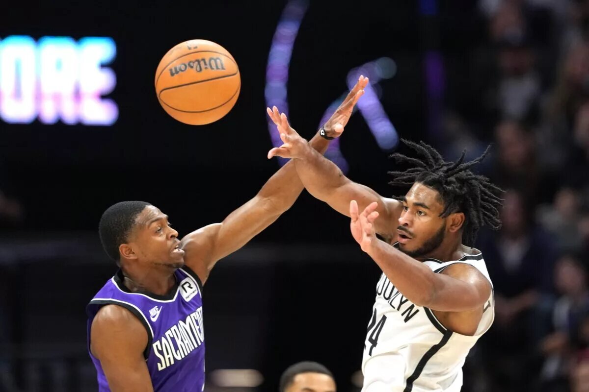 Brooklyn Nets guard Cam Thomas makes a pass while defended by Sacramento Kings guard De'Aaron Fox