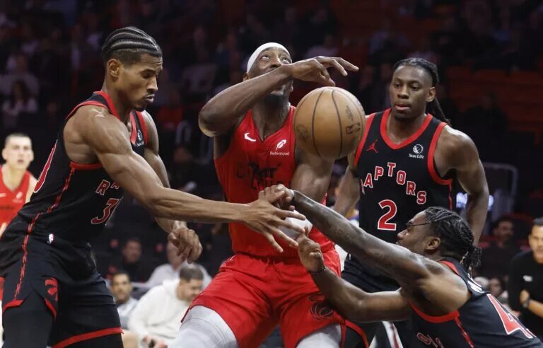 Toronto Raptors defenders led by Davion Mitchell attempt to stop Miami Heat big man Bam Adebayo