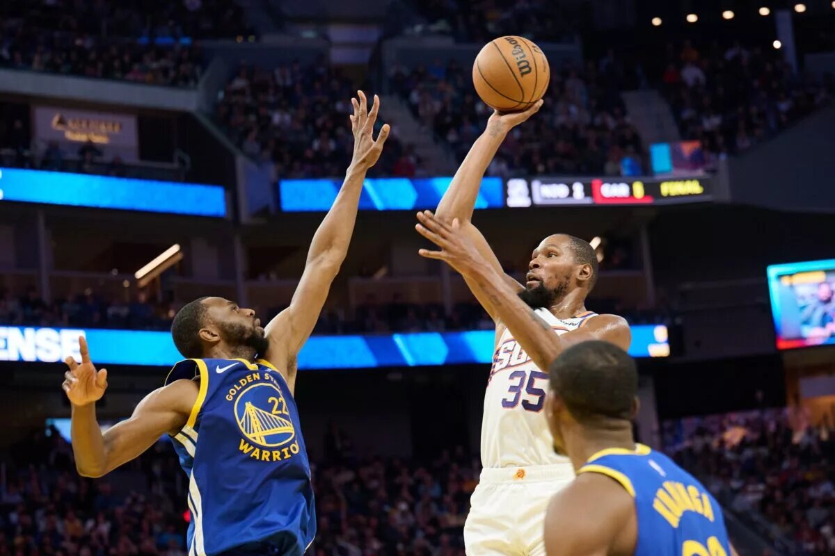 Phoenix Suns forward Kevin Durant shoots over Golden State Warriors wings Andrew Wiggins and Jonathan Kuminga