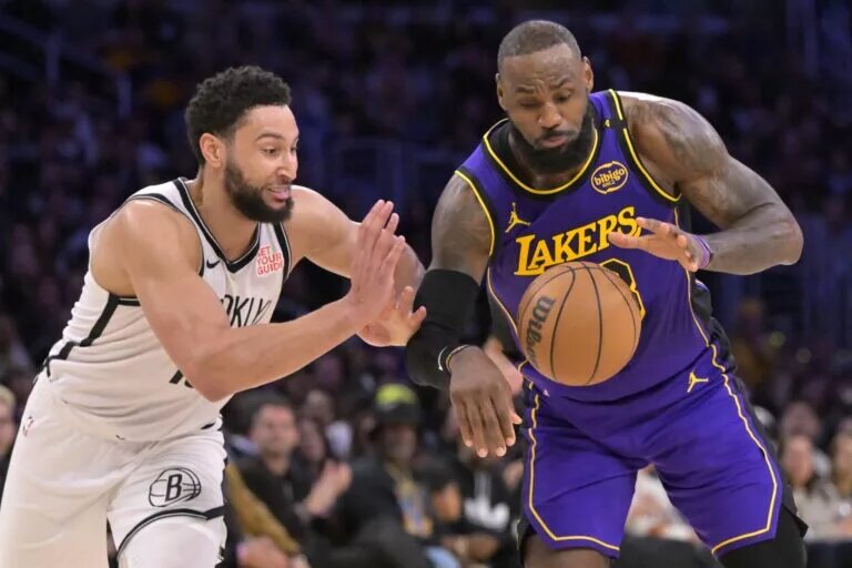 Brooklyn Nets point guard Ben Simmons defends Los Angeles Lakers forward LeBron James