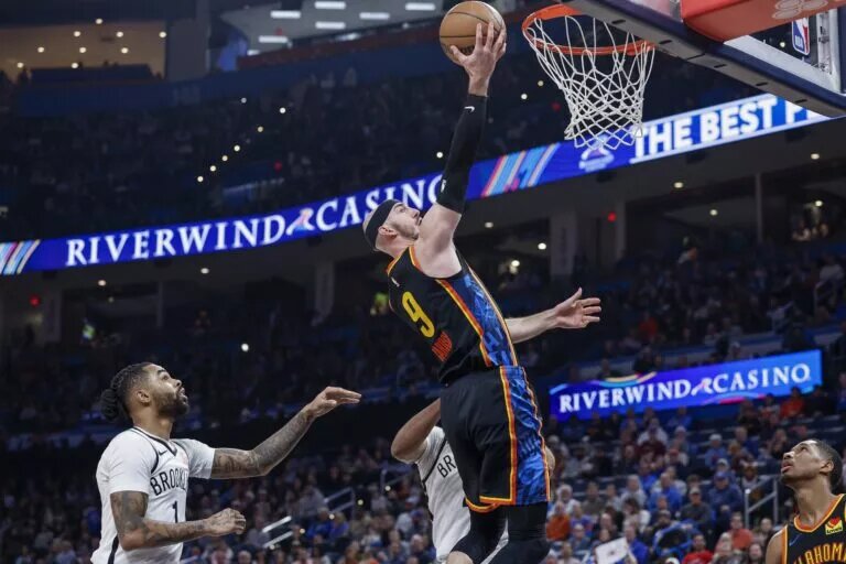 Jan 19, 2025; Oklahoma City, Oklahoma, USA; Oklahoma City Thunder guard Alex Caruso (9) goes up for a basket in front of Brooklyn Nets guard D'Angelo Russell (1) during the second half at Paycom Center. Mandatory Credit: Alonzo Adams-Imagn Images