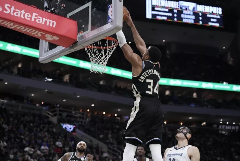 Feb 2, 2025; Milwaukee, Wisconsin, USA; Milwaukee Bucks forward Giannis Antetokounmpo (34) dunks the ball against Memphis Grizzlies center Zach Edey (14) in the first half at Fiserv Forum. Mandatory Credit: Michael McLoone-Imagn Images