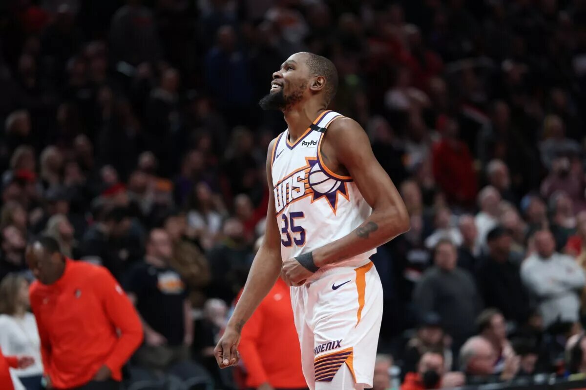 Feb 3, 2025; Portland, Oregon, USA; Phoenix Suns forward Kevin Durant (35) laughs as he watches a replay of his teammate SunsÕ guard Devin Booker (1) being fouled by Portland Trail Blazers forward Deni Avdija (8) in overtime at Moda Center. Mandatory Credit: Jaime Valdez-Imagn Images