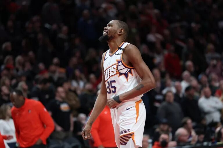 Feb 3, 2025; Portland, Oregon, USA; Phoenix Suns forward Kevin Durant (35) laughs as he watches a replay of his teammate SunsÕ guard Devin Booker (1) being fouled by Portland Trail Blazers forward Deni Avdija (8) in overtime at Moda Center. Mandatory Credit: Jaime Valdez-Imagn Images